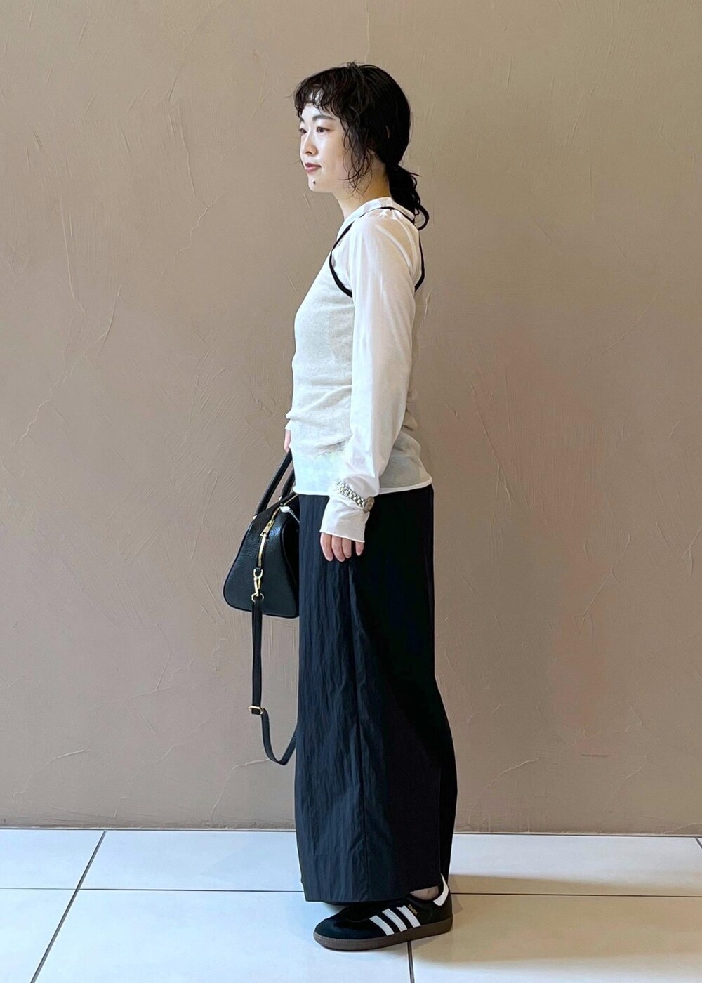 ブラック系のスカート、ベージュ系のタンクトップ、ホワイト系のTシャツ/カットソーを着用したレディースの夏コーディネートの3枚目の写真