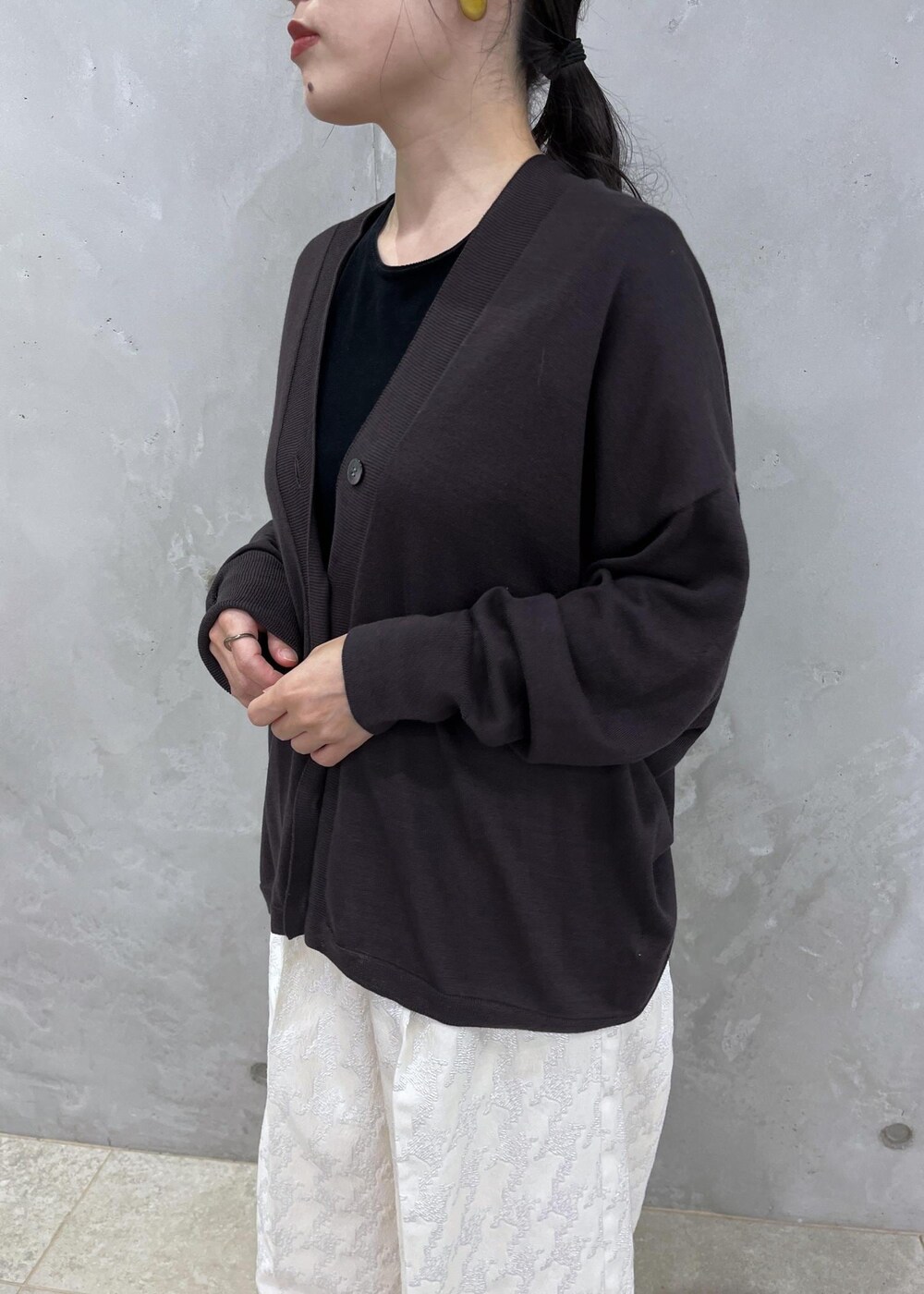 ブラック系のTシャツ/カットソー、ブラック系のハンドバッグ、ブラック系のブーツを着用したレディースの夏コーディネートの6枚目の写真