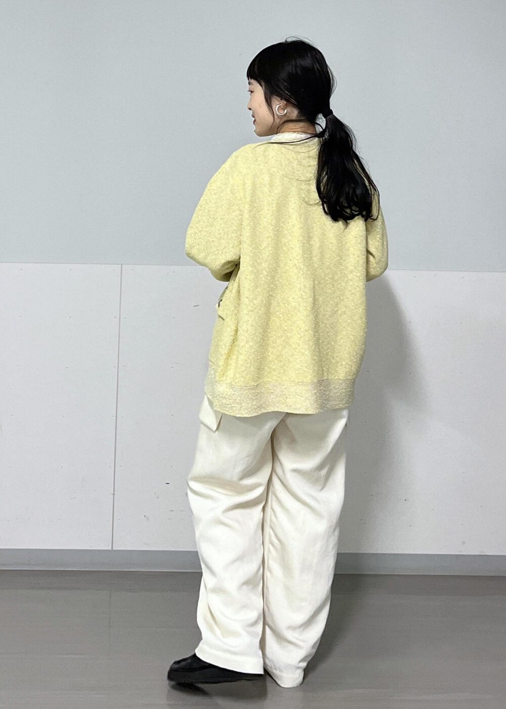 ホワイト系のカーゴパンツ、ホワイト系のTシャツ/カットソー、イエロー系のカーディガン/ボレロを着用したレディースの冬コーディネートの3枚目の写真