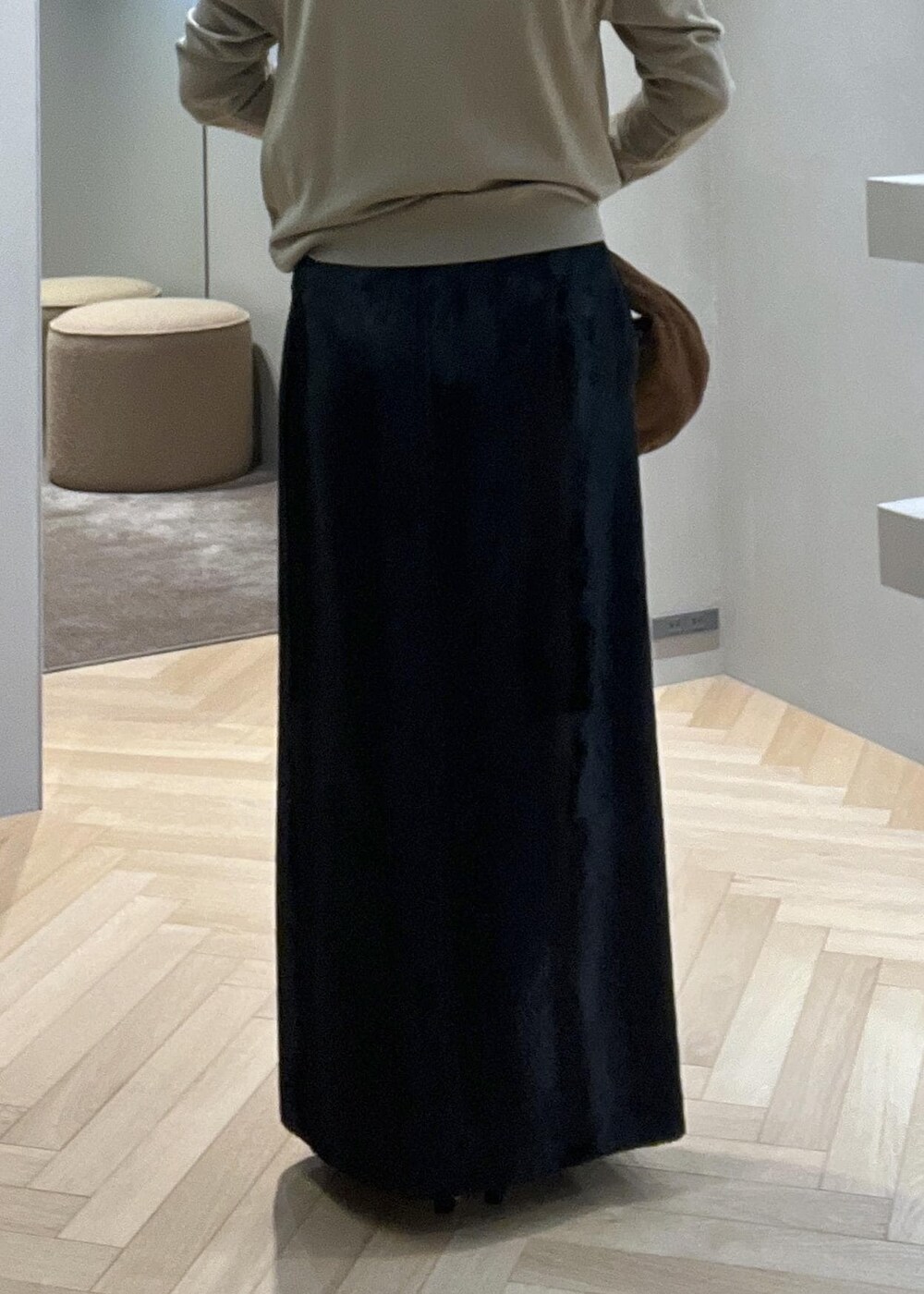 ブラック系のブーツ、ブラック系のスカート、ベージュ系のニット/セーターを着用したレディースの冬コーディネートの7枚目の写真