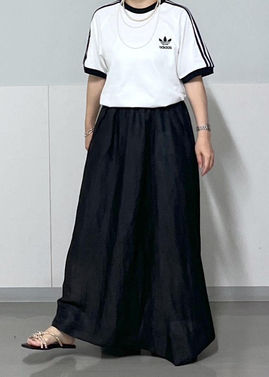 ブラック系のスカート、ゴールド系のサンダル、シルバー系のハンドバッグを着用したレディースの夏コーディネートの3枚目の写真