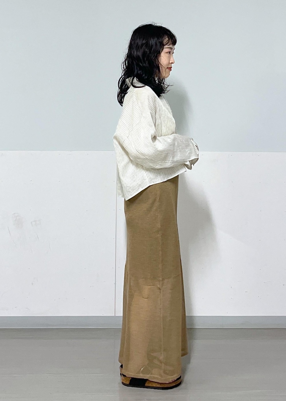 ブラック系のハンドバッグ、ホワイト系のシャツ/ブラウス、ゴールド系のスカートを着用したレディースの夏コーディネートの4枚目の写真