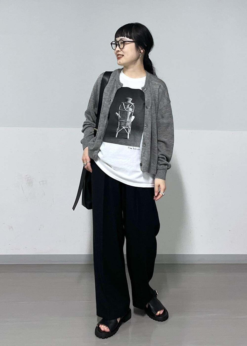 ブラック系のサンダル、グレー系のカーディガン/ボレロ、ブラック系のスラックスを着用したレディースの春コーディネートの2枚目の写真