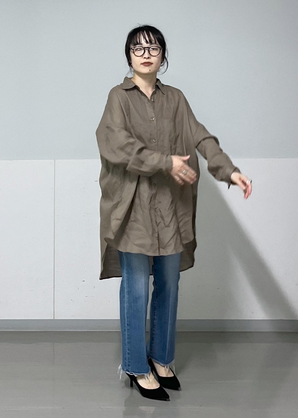 グリーン系のシャツ/ブラウス、ブラック系のショルダーバッグ、ブルー系のデニムパンツを着用したレディースの春コーディネートの5枚目の写真