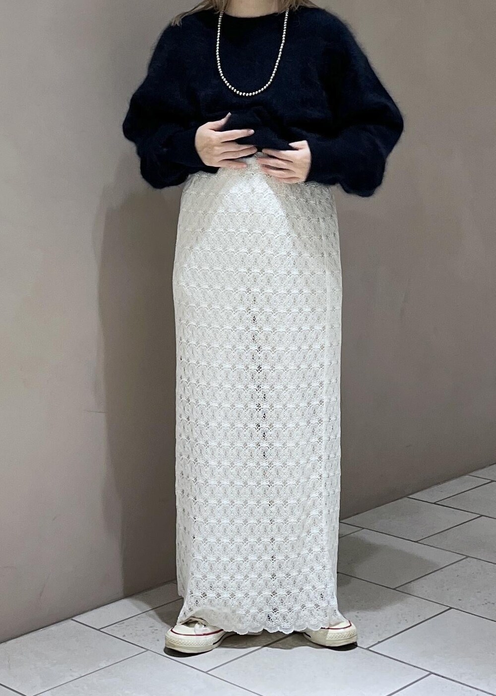 ホワイト系のスカート、ブルー系のニット/セーター、ホワイト系のスラックスを着用したレディースの秋コーディネートの5枚目の写真