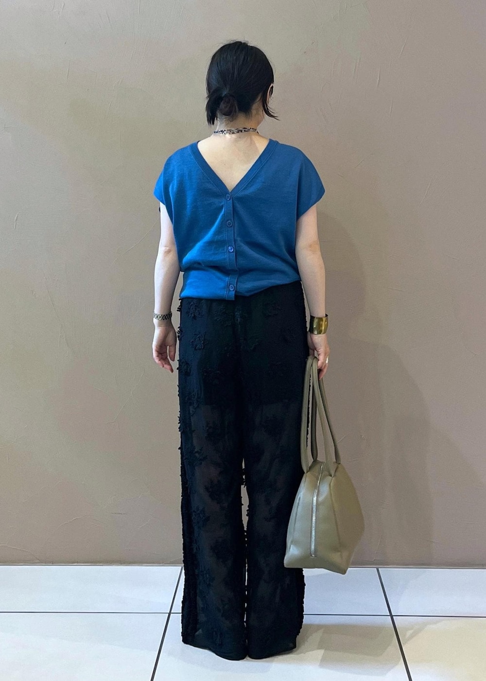 ブラック系のサンダル、ブルー系のカーディガン/ボレロ、ベージュ系のボストンバッグを着用したレディースの夏コーディネートの3枚目の写真