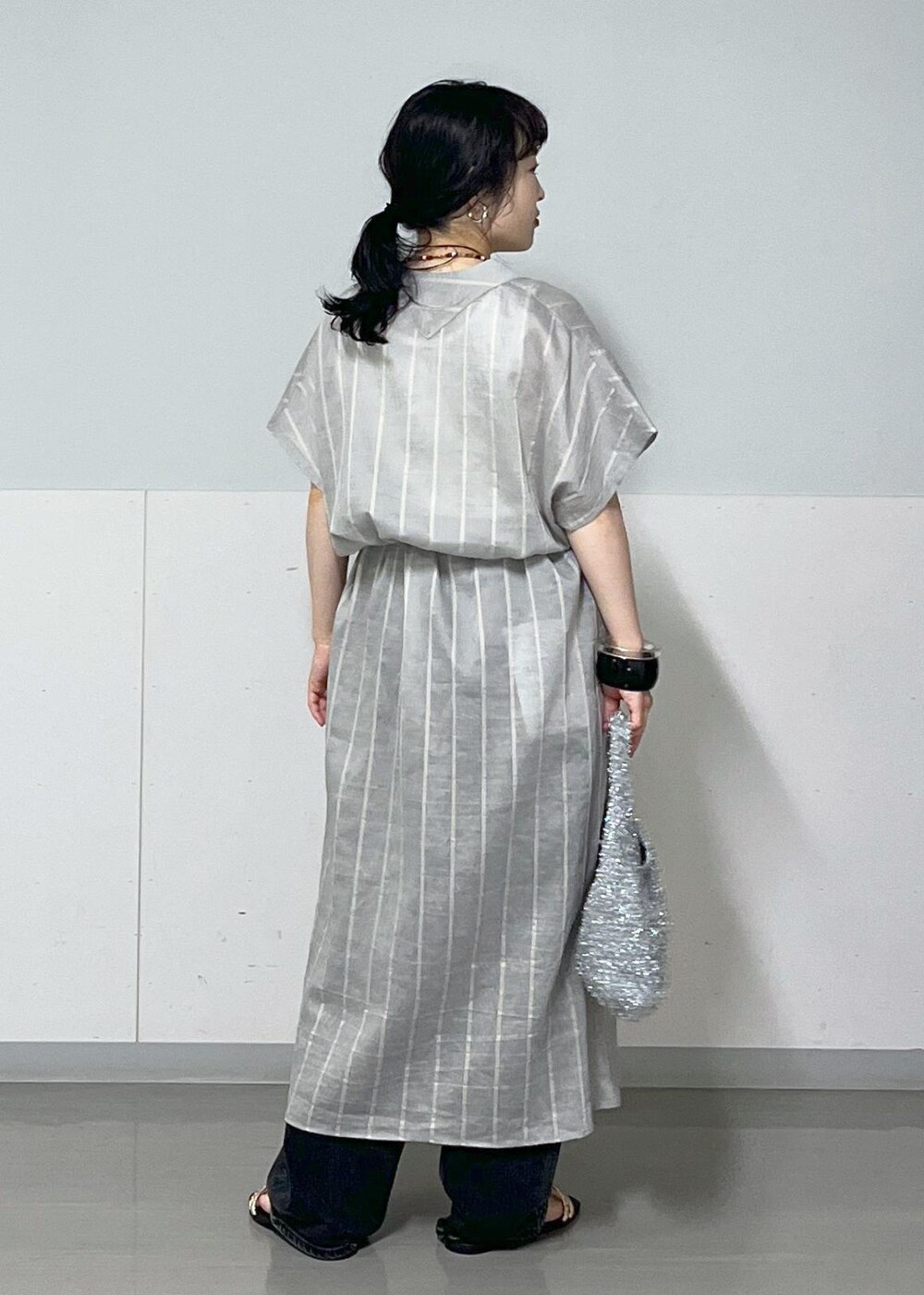 ブルー系のワンピース、ホワイト系のタンクトップ、シルバー系のハンドバッグを着用したレディースの夏コーディネートの3枚目の写真