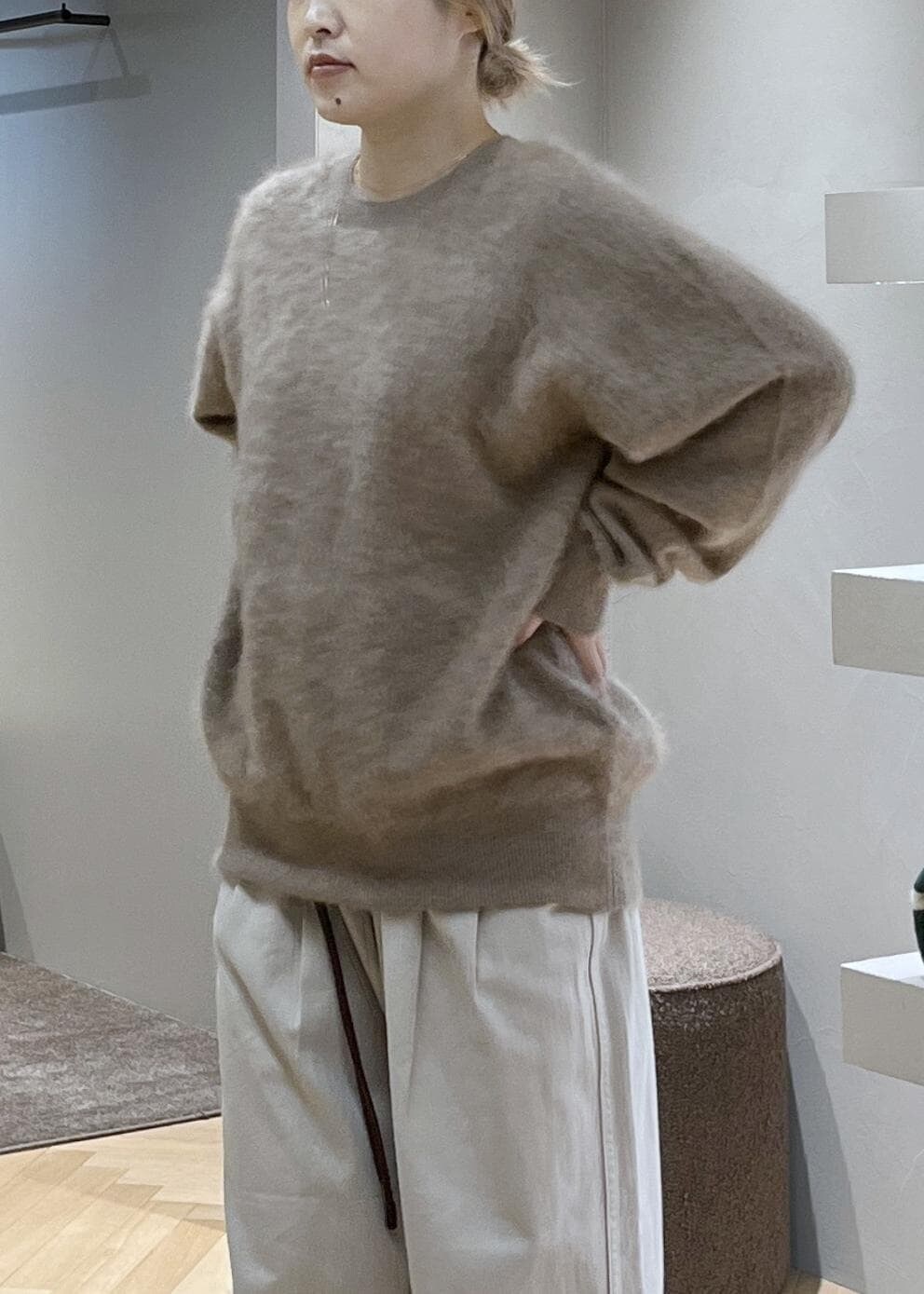 ブラウン系のショルダーバッグ、ベージュ系のニット/セーター、ホワイト系のデニムパンツを着用したレディースの冬コーディネートの4枚目の写真
