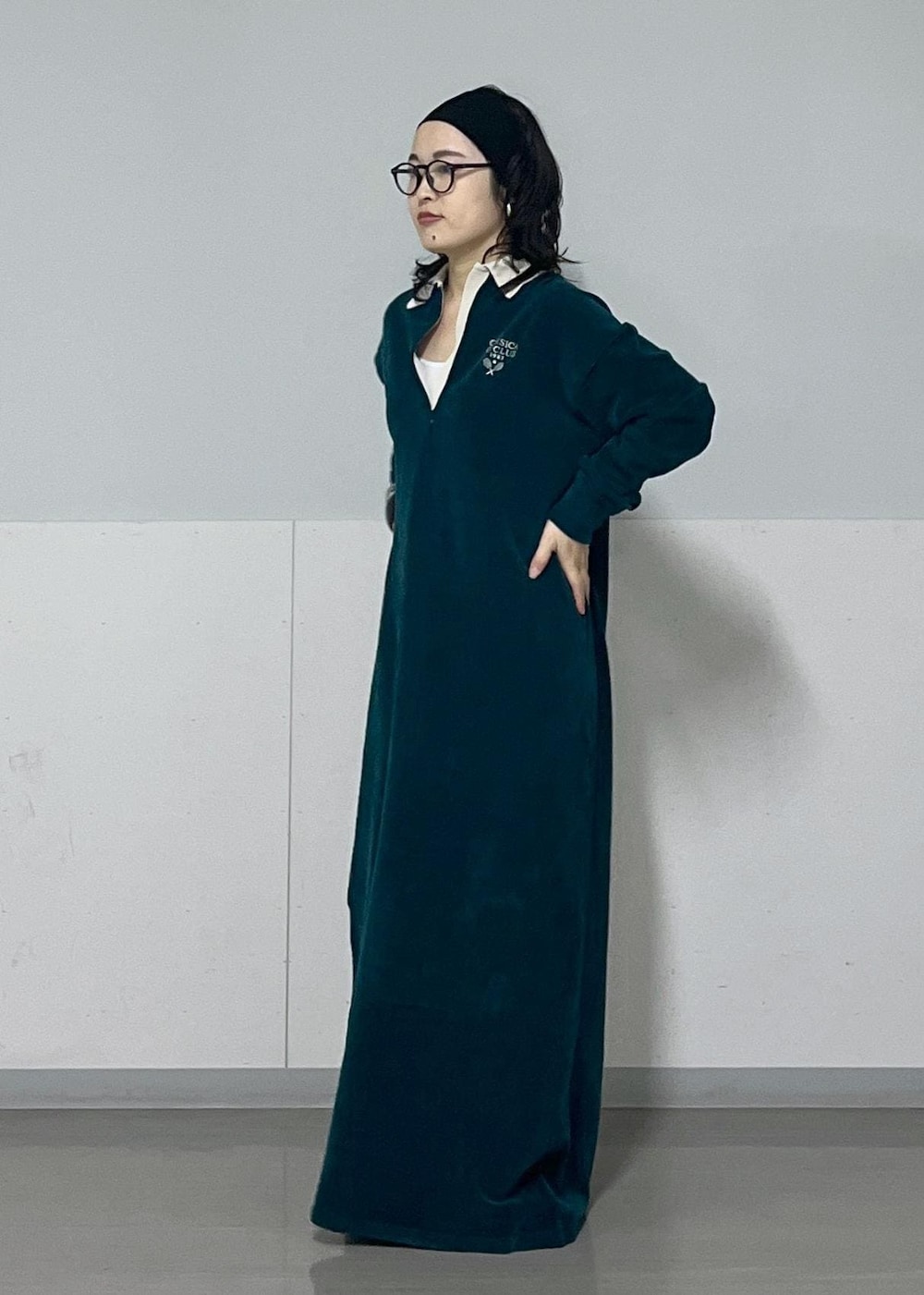 ホワイト系のハンドバッグ、ホワイト系のカーディガン/ボレロ、グリーン系のワンピースを着用したレディースの冬コーディネートの4枚目の写真