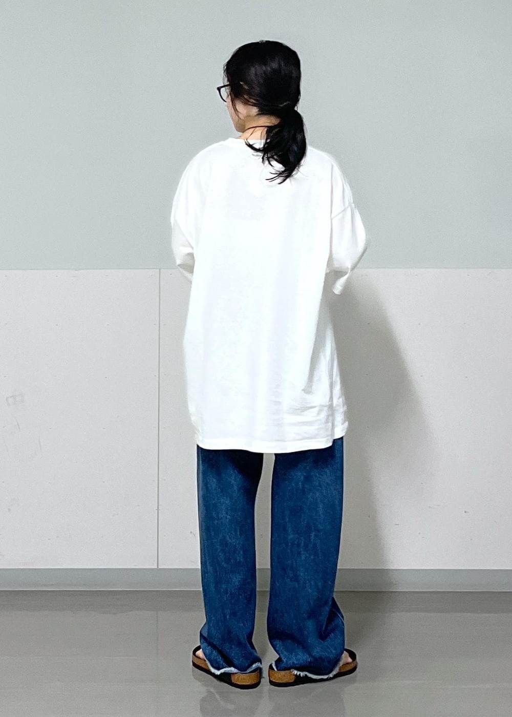 ブラック系のトートバッグ、ブルー系のデニムパンツ、ホワイト系のTシャツ/カットソーを着用したレディースの夏コーディネートの5枚目の写真