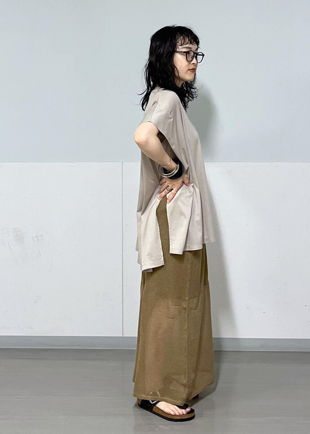 ベージュ系のTシャツ/カットソー、ゴールド系のスカート、イエロー系のバンダナ/スカーフを着用したレディースの夏コーディネートの4枚目の写真