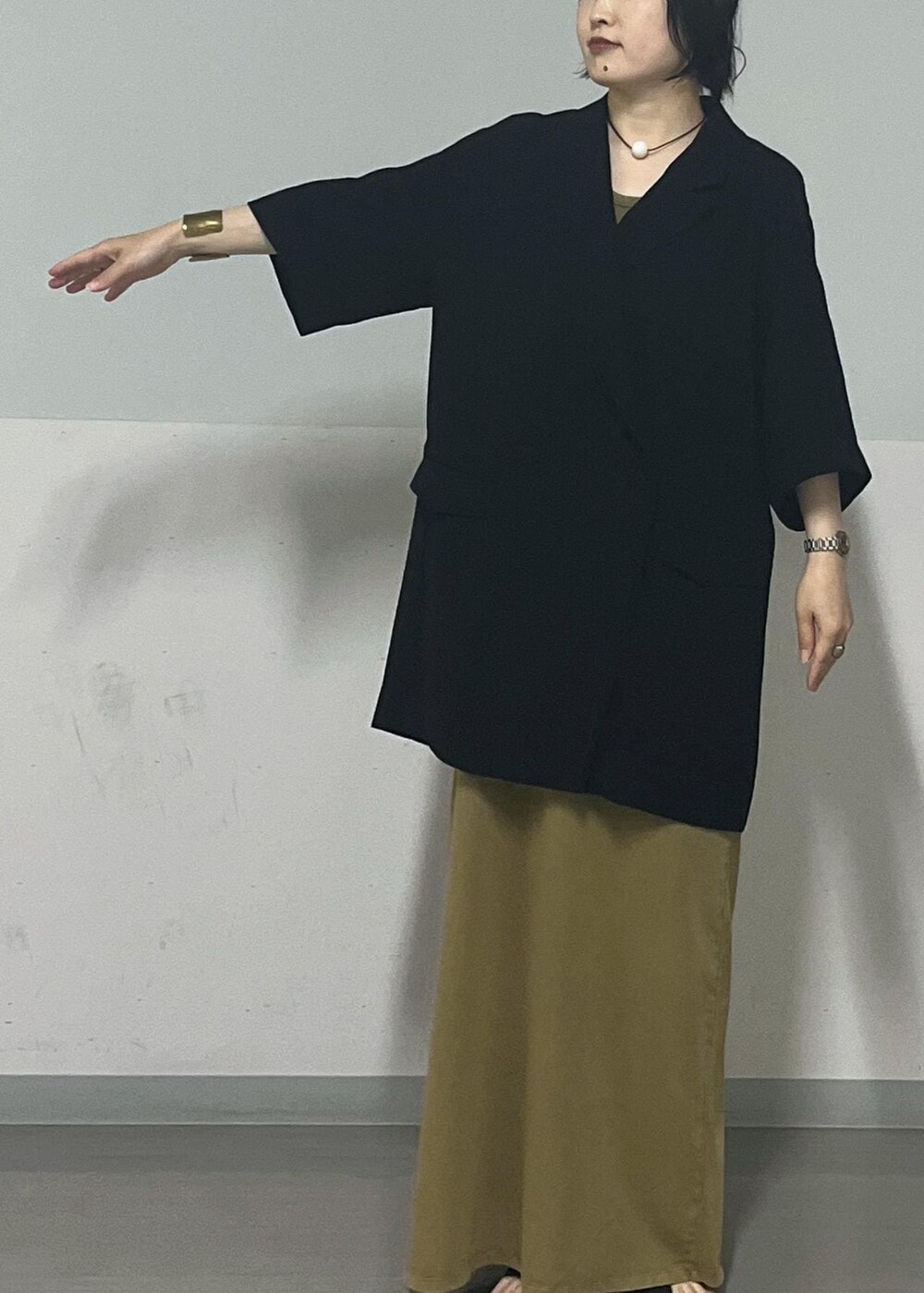 ブラック系のサンダル、ブラック系のテーラードジャケット、ブラウン系のワンピースを着用したレディースの夏コーディネートの5枚目の写真