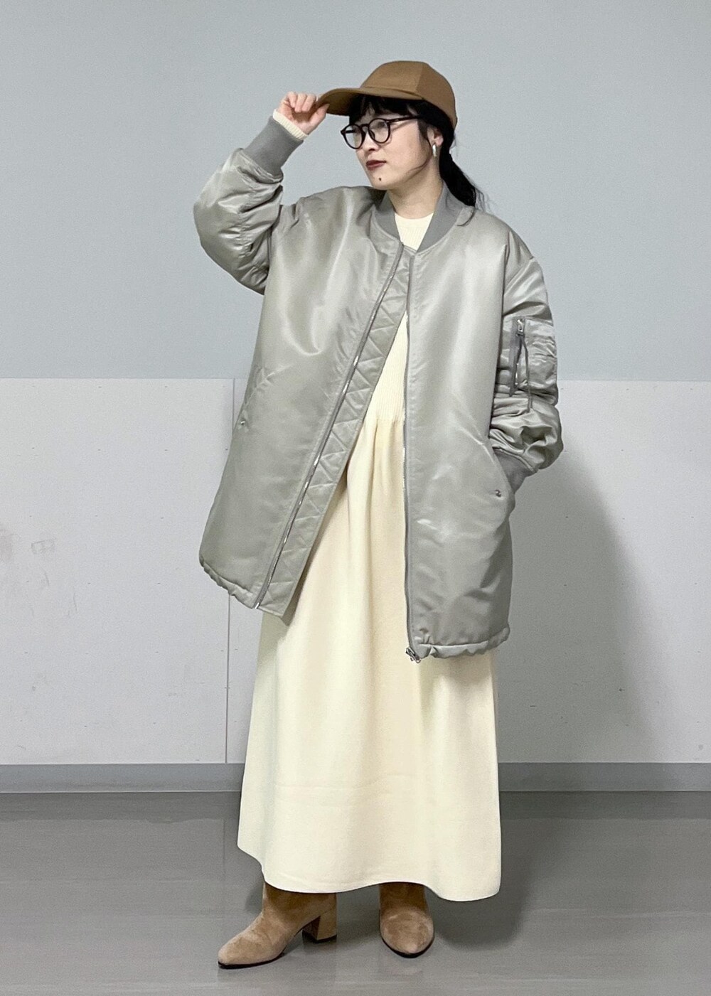 ブラウン系のブーツ、グレー系のMA-1、ホワイト系のワンピースを着用したレディースの冬コーディネートの5枚目の写真