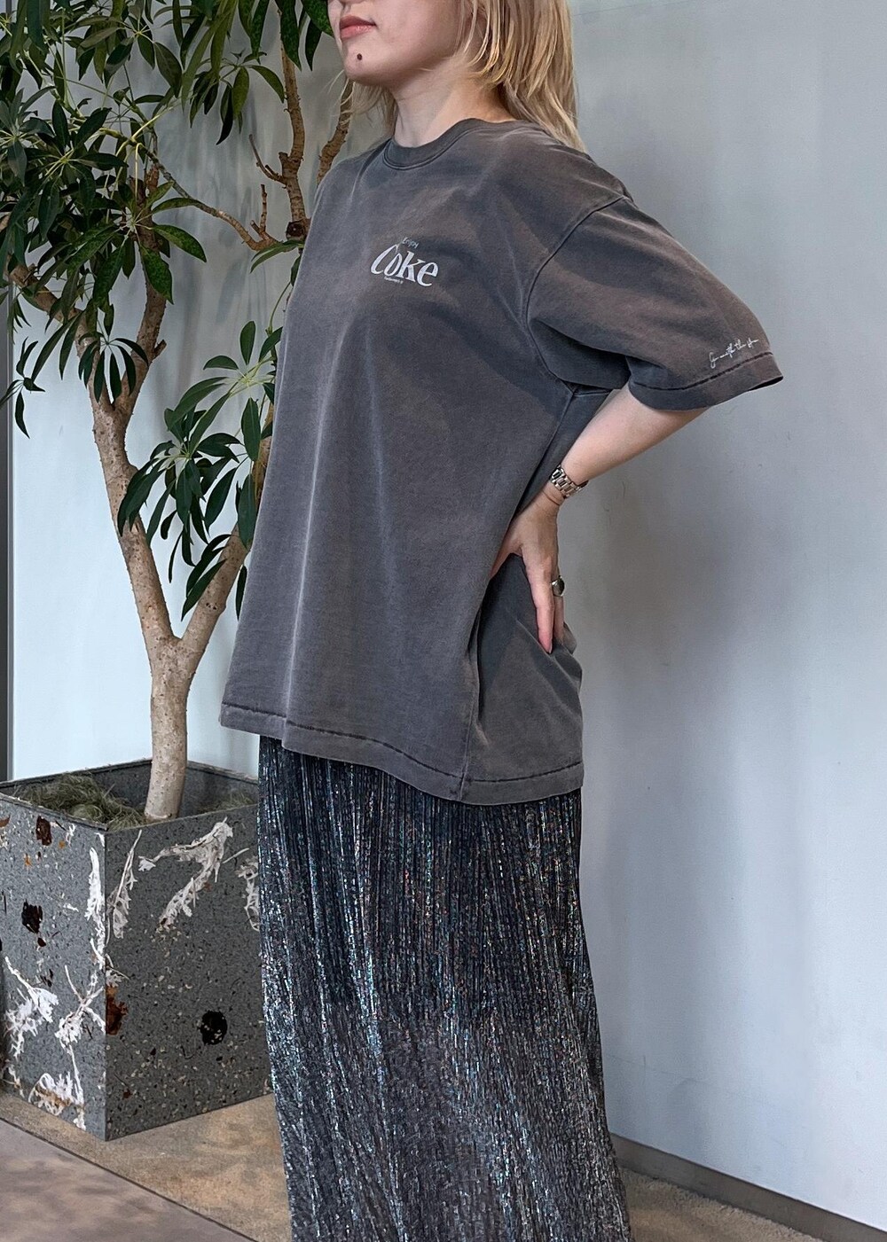 ブラウン系のショルダーバッグ、シルバー系のスカート、グレー系のTシャツ/カットソーを着用したレディースの夏コーディネートの6枚目の写真