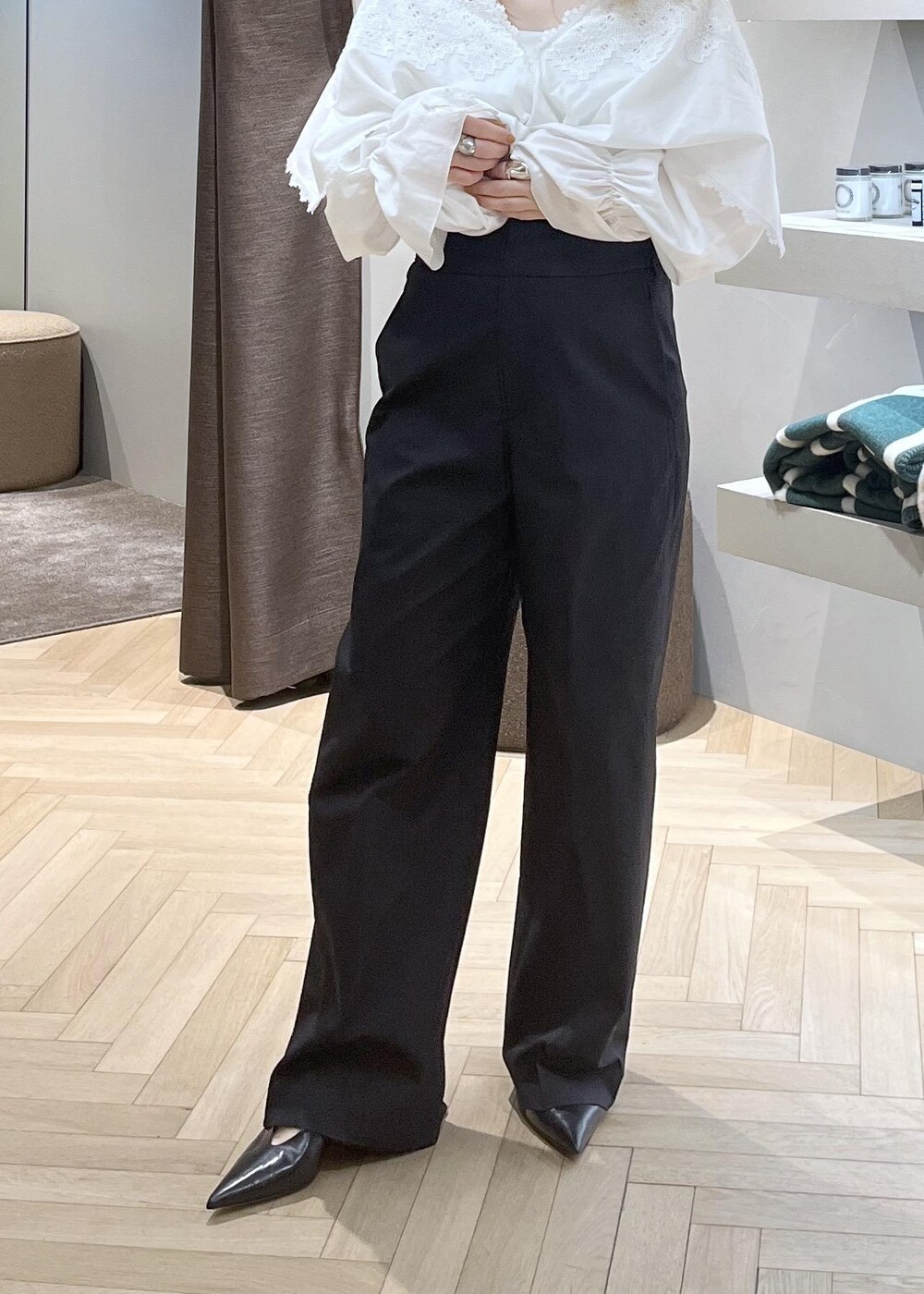 ブラック系のスラックス、ブラック系のパンプス、ホワイト系のシャツ/ブラウスを着用したレディースの冬コーディネートの8枚目の写真