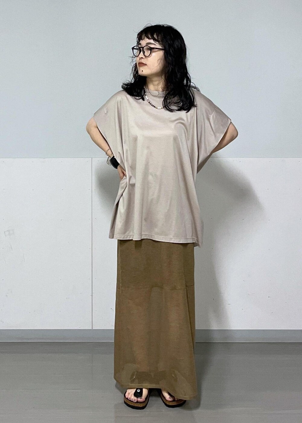 ベージュ系のTシャツ/カットソー、ゴールド系のスカート、イエロー系のバンダナ/スカーフを着用したレディースの夏コーディネートの3枚目の写真