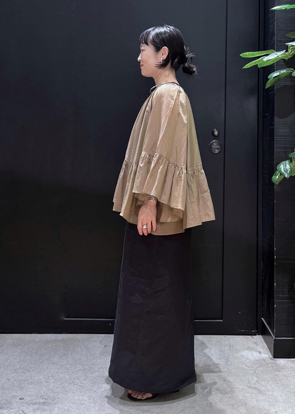 ブラック系のサンダル、ベージュ系のシャツ/ブラウス、ブラック系のジャンパースカートを着用したレディースの夏コーディネートの2枚目の写真