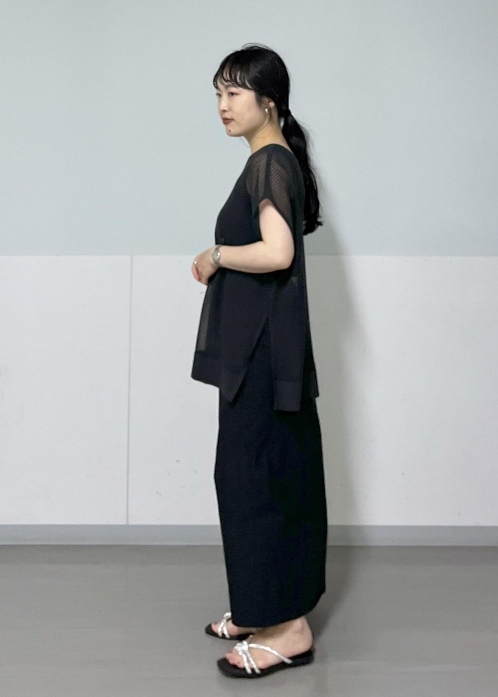 シルバー系のサンダル、ホワイト系のショルダーバッグ、ブラック系のタンクトップを着用したレディースの春コーディネートの5枚目の写真