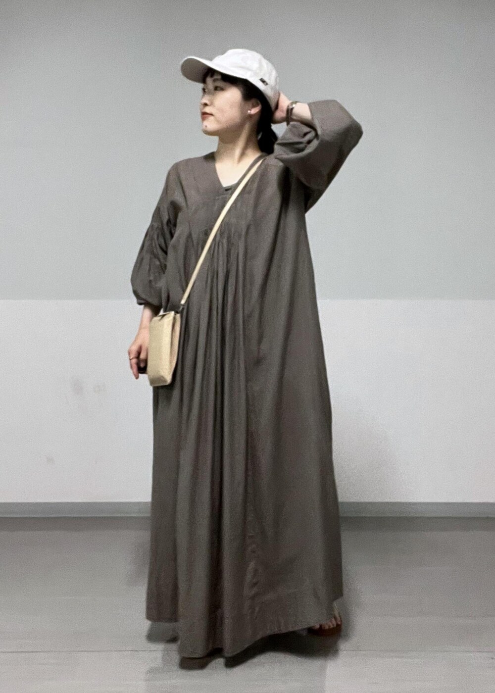 ブラウン系のサンダル、ベージュ系のショルダーバッグ、グレー系のワンピースを着用したレディースの夏コーディネートの3枚目の写真