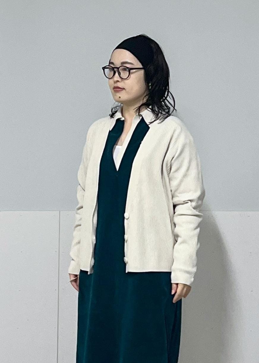 ホワイト系のハンドバッグ、ホワイト系のカーディガン/ボレロ、グリーン系のワンピースを着用したレディースの冬コーディネートの7枚目の写真