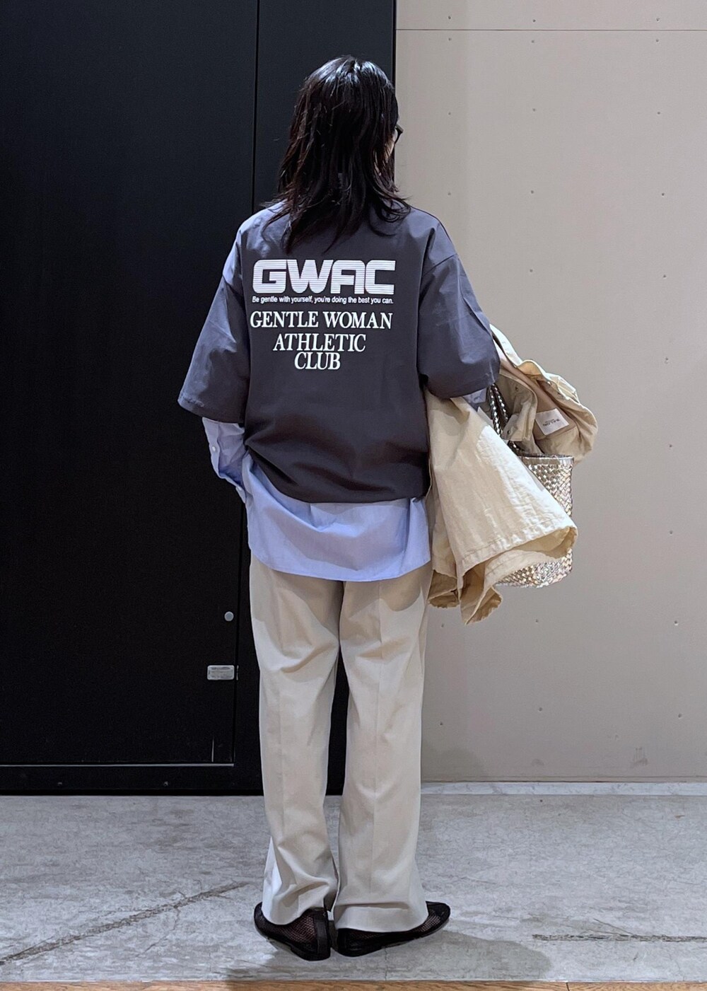 グレー系のスラックス、ベージュ系のブルゾン、ブラック系のパンプスを着用したレディースの春コーディネートの3枚目の写真