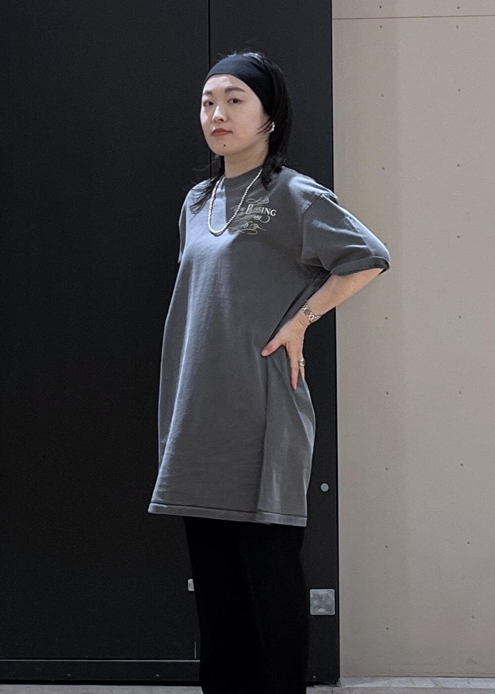 ブラック系のショルダーバッグ、ブラック系のその他パンツ、ベージュ系のTシャツ/カットソーを着用したレディースの春コーディネートの7枚目の写真