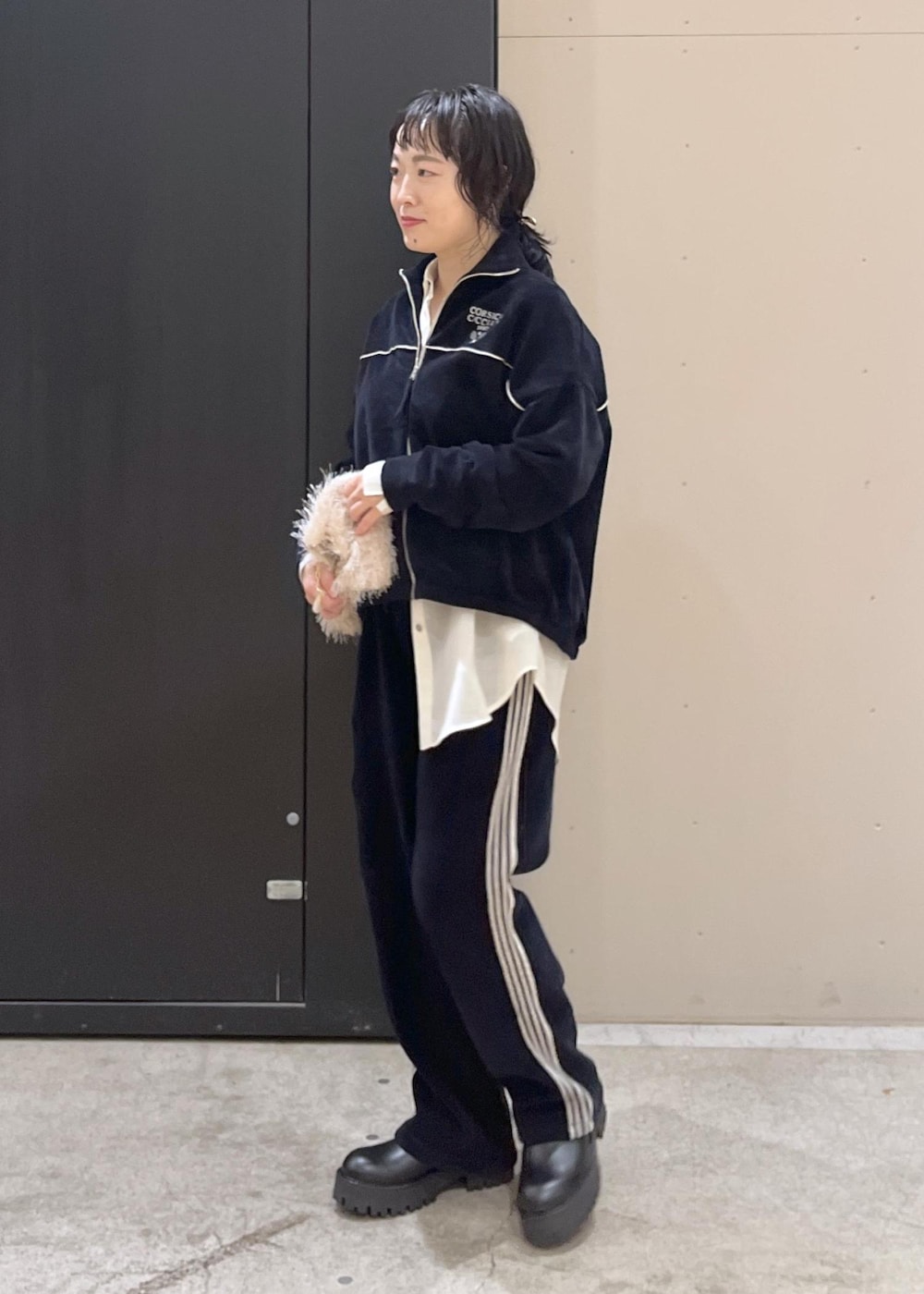 ブラック系のブーツ、ホワイト系のシャツ/ブラウス、ホワイト系のハンドバッグを着用したレディースの冬コーディネートの2枚目の写真