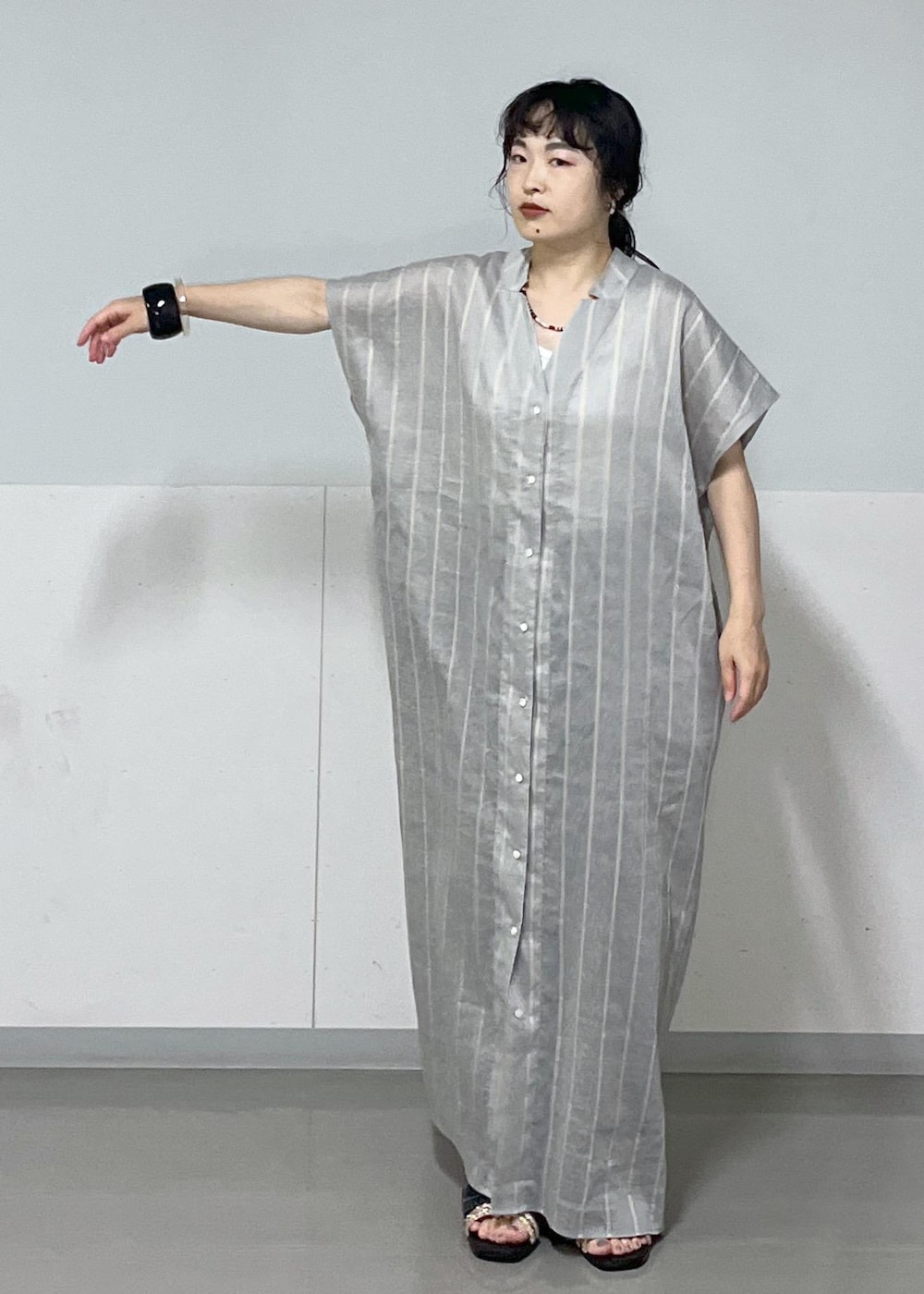 ブルー系のワンピース、ホワイト系のタンクトップ、シルバー系のハンドバッグを着用したレディースの夏コーディネートの4枚目の写真