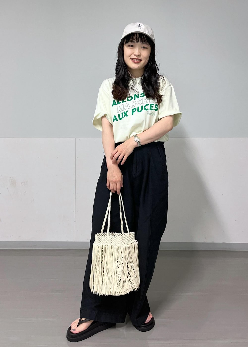 ブラック系のデニムパンツ、グリーン系のTシャツ/カットソー、ブラック系のサンダルを着用したレディースの夏コーディネートの2枚目の写真