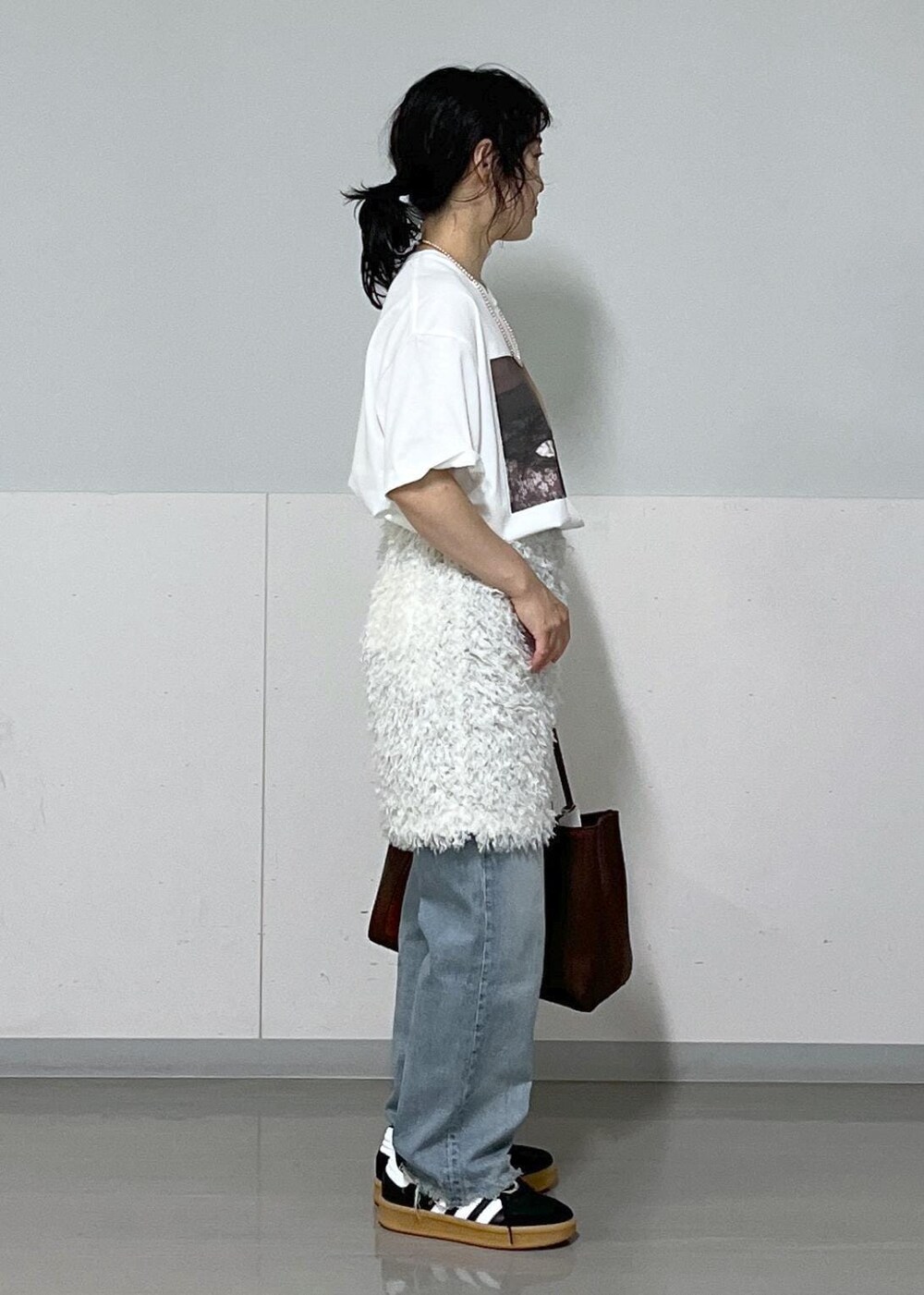 ホワイト系のTシャツ/カットソー、ホワイト系のスカート、ブラウン系のハンドバッグを着用したレディースの夏コーディネートの4枚目の写真