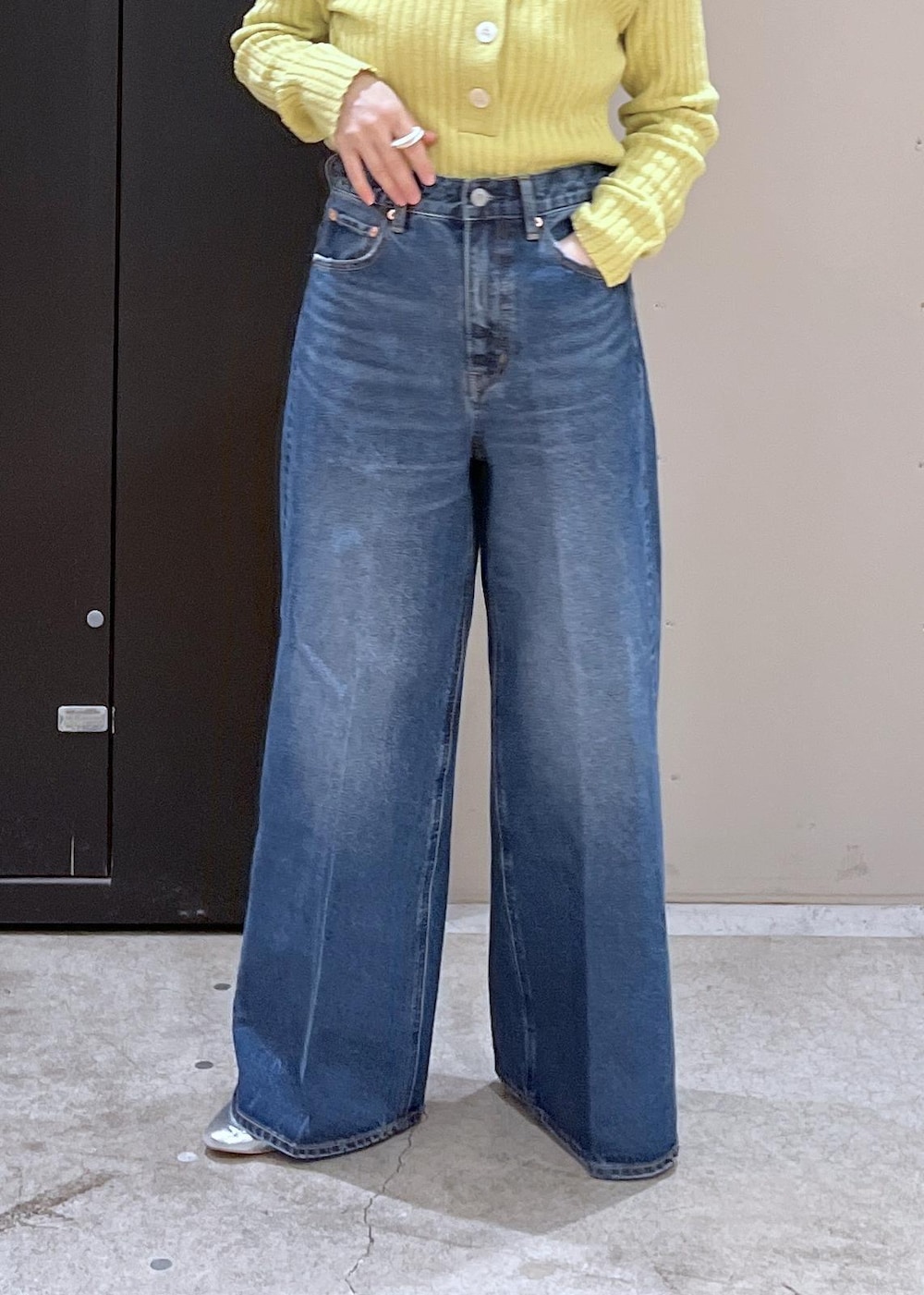 イエロー系のニット/セーター、ブルー系のデニムパンツ、ブラック系のその他アウターを着用したレディースの冬コーディネートの7枚目の写真