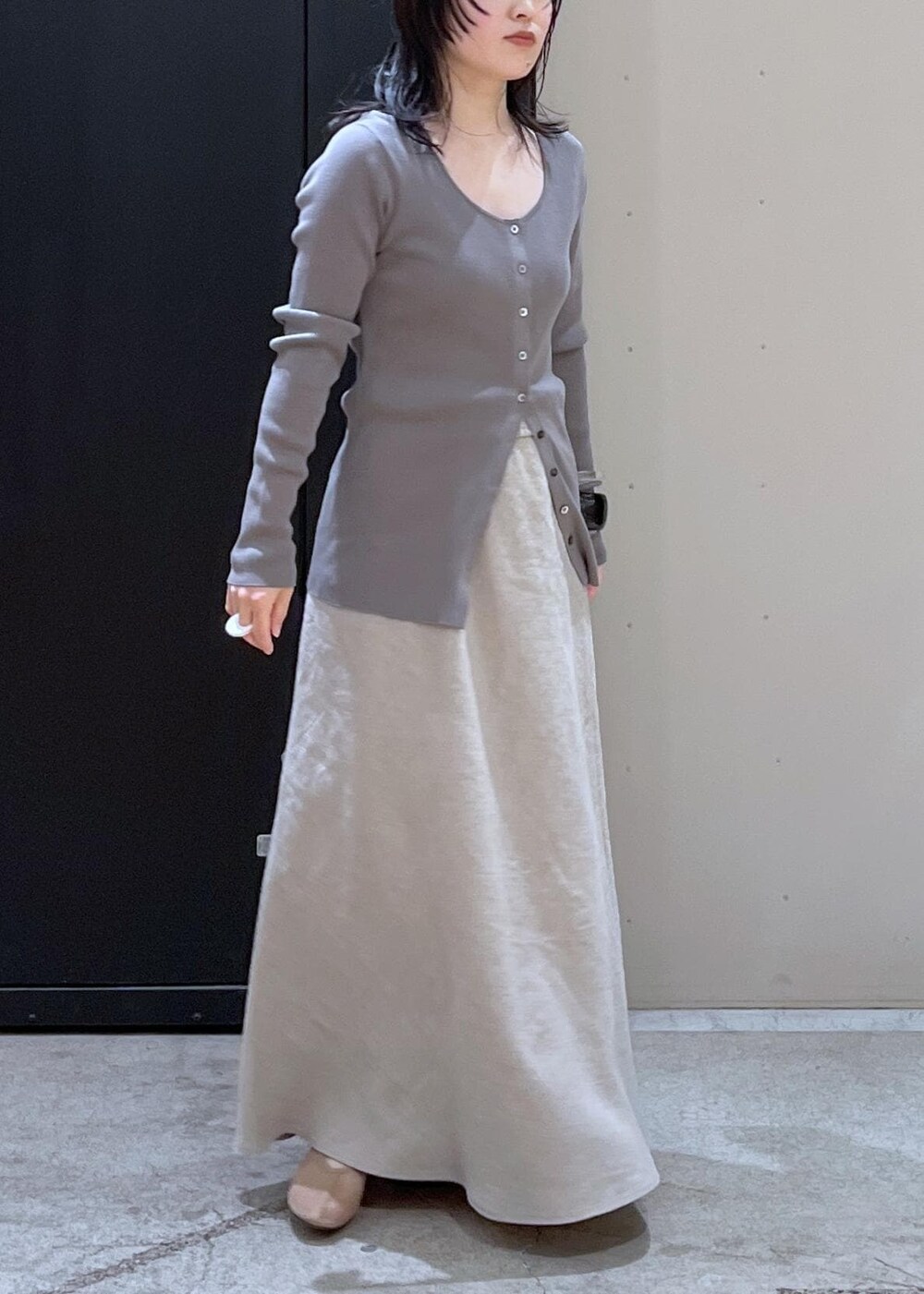 ブラック系のボストンバッグ、ベージュ系のパンプス、ベージュ系のスカートを着用したレディースの冬コーディネートの5枚目の写真