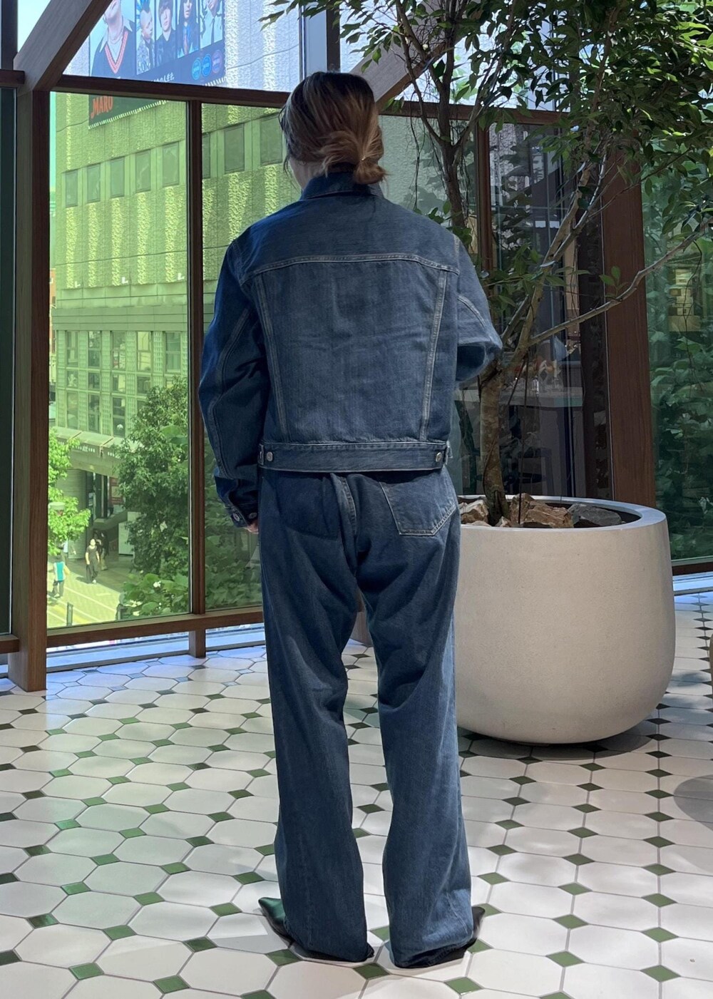 ベージュ系のショルダーバッグ、ブラック系のダウンジャケット/コート、ブルー系のデニムジャケットを着用したレディースの秋コーディネートの5枚目の写真