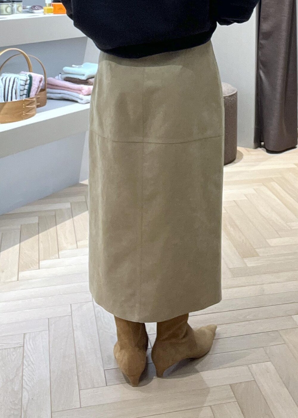 ベージュ系のスカート、ブラック系のショルダーバッグ、イエロー系のブーツを着用したレディースの冬コーディネートの6枚目の写真