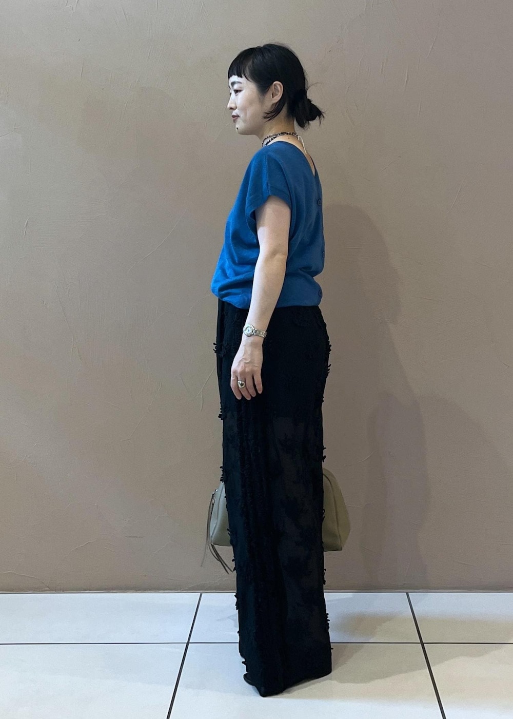 ブラック系のサンダル、ブルー系のカーディガン/ボレロ、ベージュ系のボストンバッグを着用したレディースの夏コーディネートの2枚目の写真