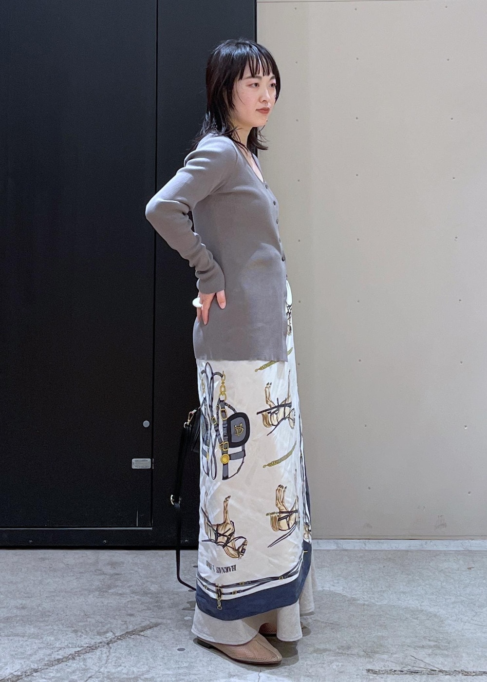 ブラック系のボストンバッグ、ベージュ系のパンプス、ベージュ系のスカートを着用したレディースの冬コーディネートの2枚目の写真