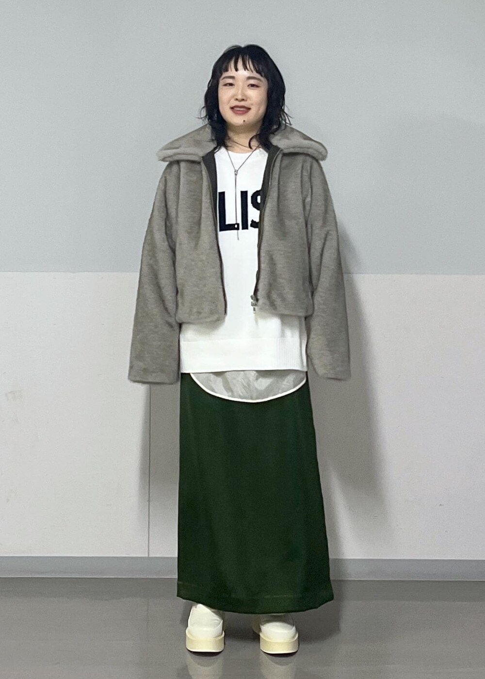 グリーン系のスカート、ホワイト系のシャツ/ブラウス、グレー系のブルゾンを着用したレディースの冬コーディネートの4枚目の写真