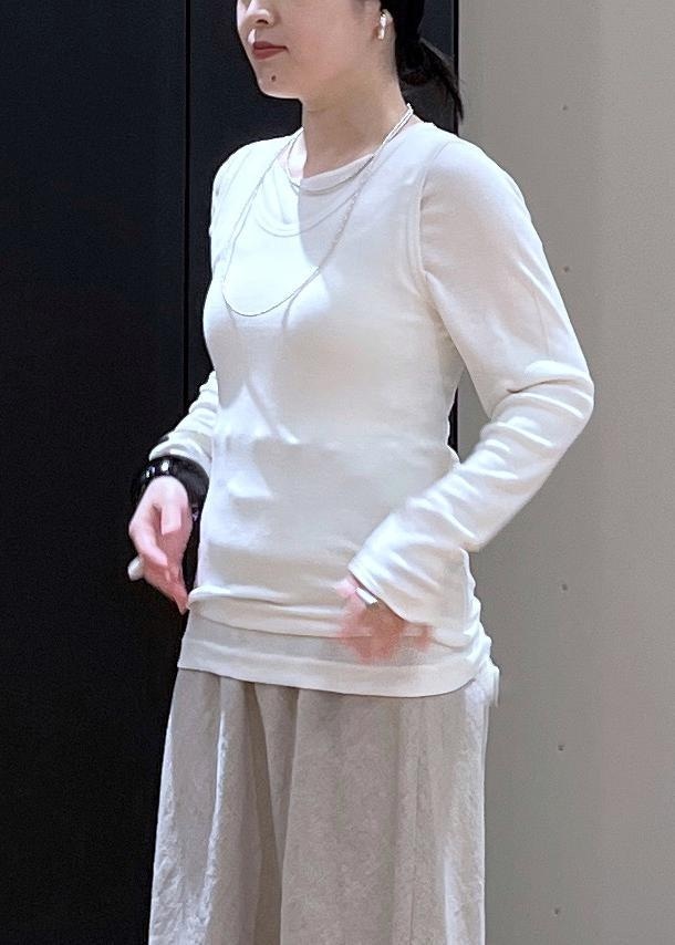 ベージュ系のスニーカー、ベージュ系のスカート、ホワイト系のタンクトップを着用したレディースの春コーディネートの4枚目の写真