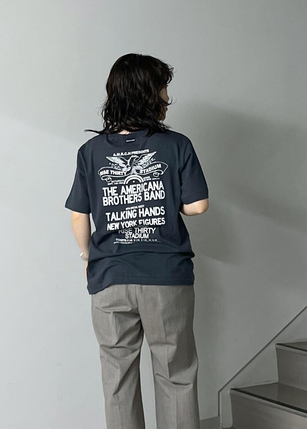 ブルー系のトートバッグ、グレー系のスラックス、ブラック系のTシャツ/カットソーを着用したレディースの秋コーディネートの8枚目の写真