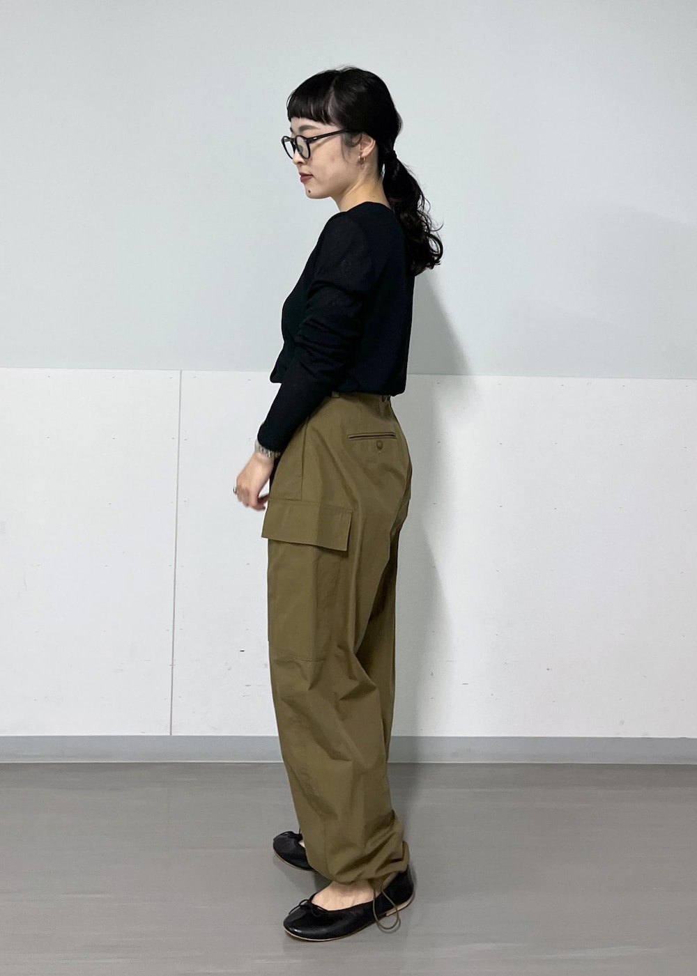 グリーン系のカーゴパンツ、ブラック系のハンドバッグ、ブラック系のカーディガン/ボレロを着用したレディースの夏コーディネートの4枚目の写真