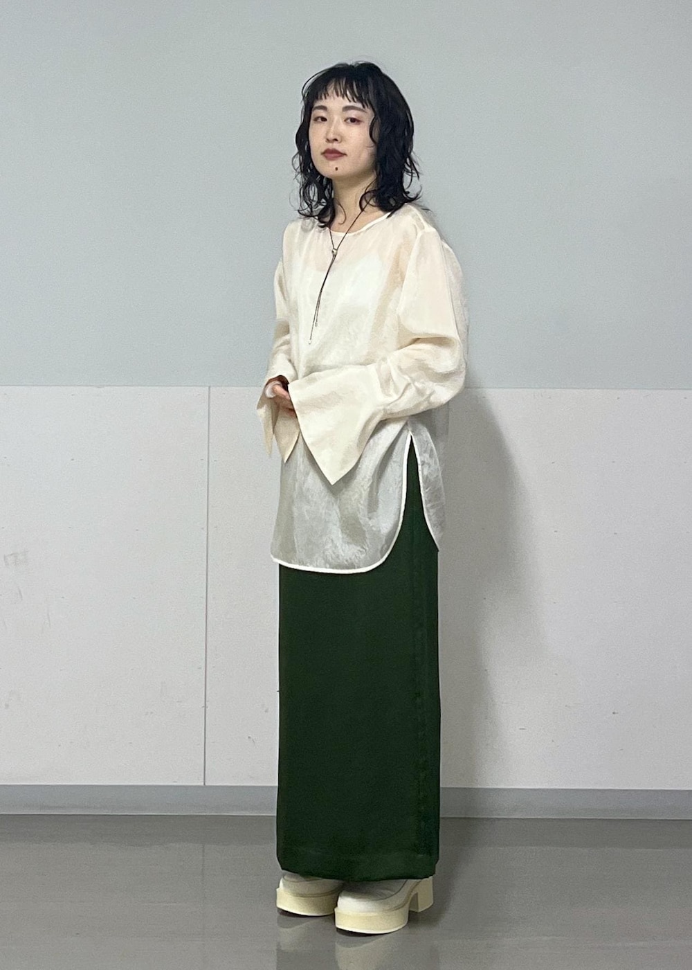 グリーン系のスカート、ホワイト系のシャツ/ブラウス、グレー系のブルゾンを着用したレディースの冬コーディネートの8枚目の写真