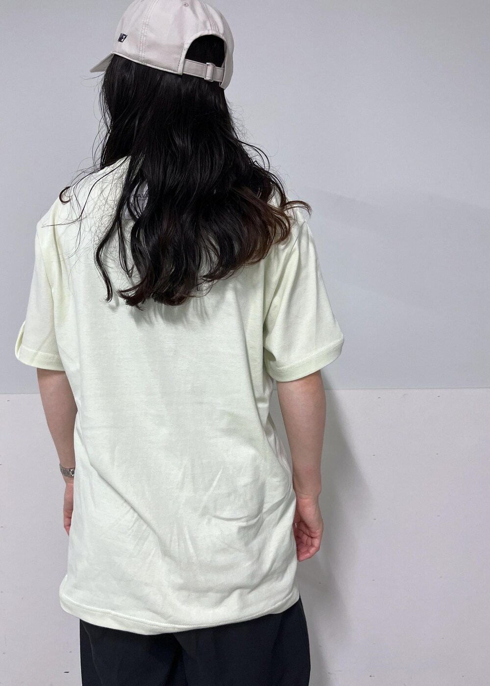 ブラック系のデニムパンツ、グリーン系のTシャツ/カットソー、ブラック系のサンダルを着用したレディースの夏コーディネートの6枚目の写真