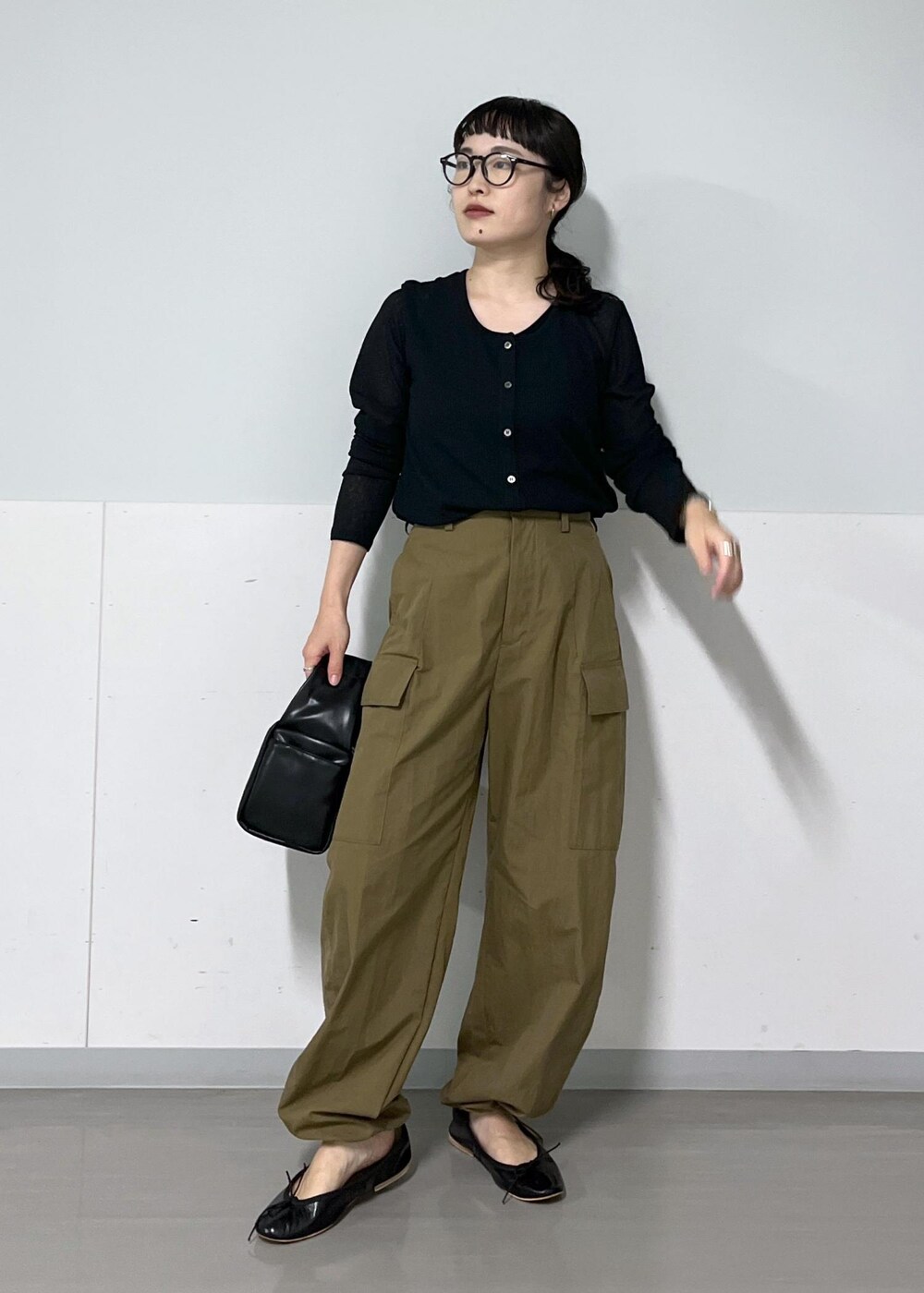 グリーン系のカーゴパンツ、ブラック系のハンドバッグ、ブラック系のカーディガン/ボレロを着用したレディースの夏コーディネートの3枚目の写真