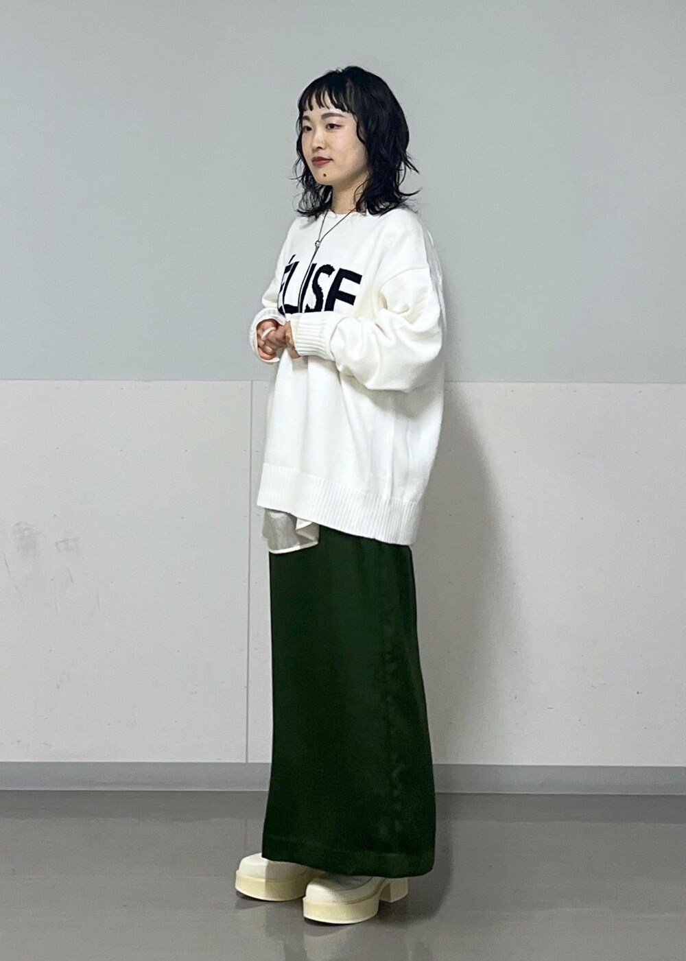 グリーン系のスカート、ホワイト系のシャツ/ブラウス、グレー系のブルゾンを着用したレディースの冬コーディネートの6枚目の写真