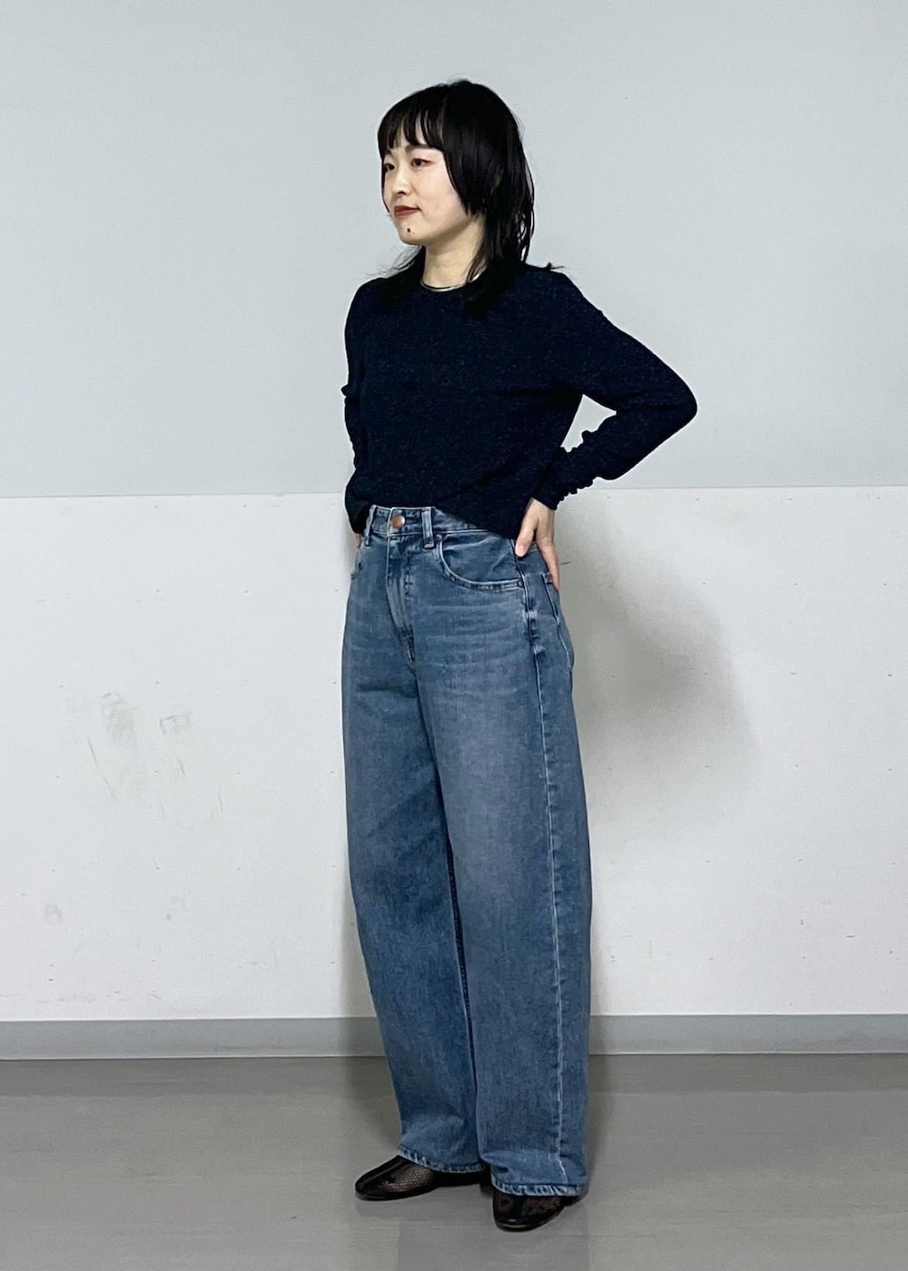 ブラック系のパンプス、ブルー系のデニムパンツ、ホワイト系のカーディガン/ボレロを着用したレディースの冬コーディネートの5枚目の写真
