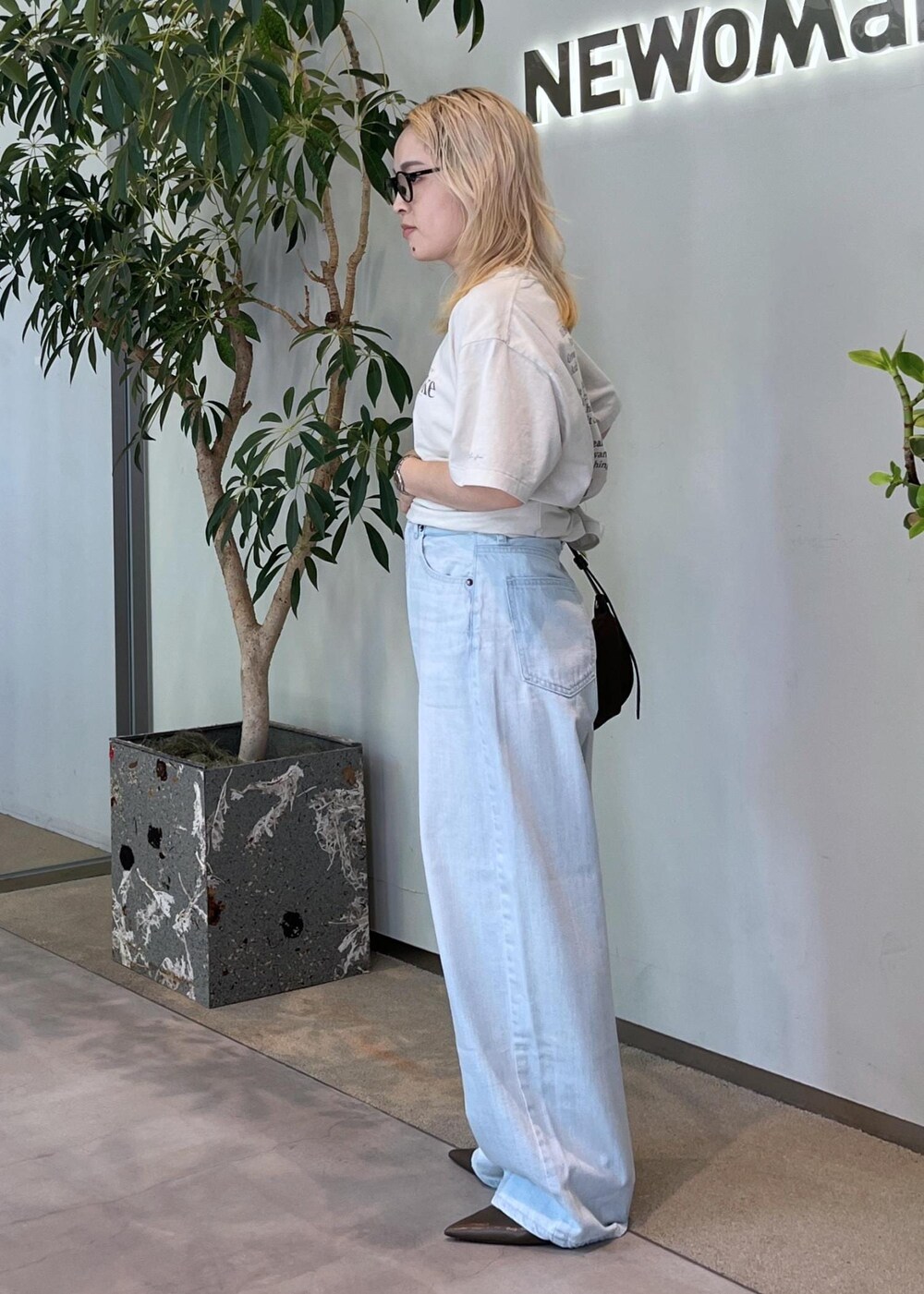 ブルー系のデニムパンツ、グリーン系のパンプス、ブラウン系のショルダーバッグを着用したレディースの夏コーディネートの7枚目の写真