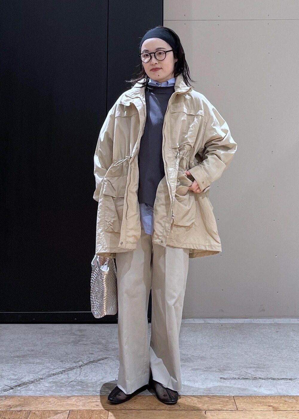 グレー系のスラックス、ベージュ系のブルゾン、ブラック系のパンプスを着用したレディースの春コーディネートの4枚目の写真