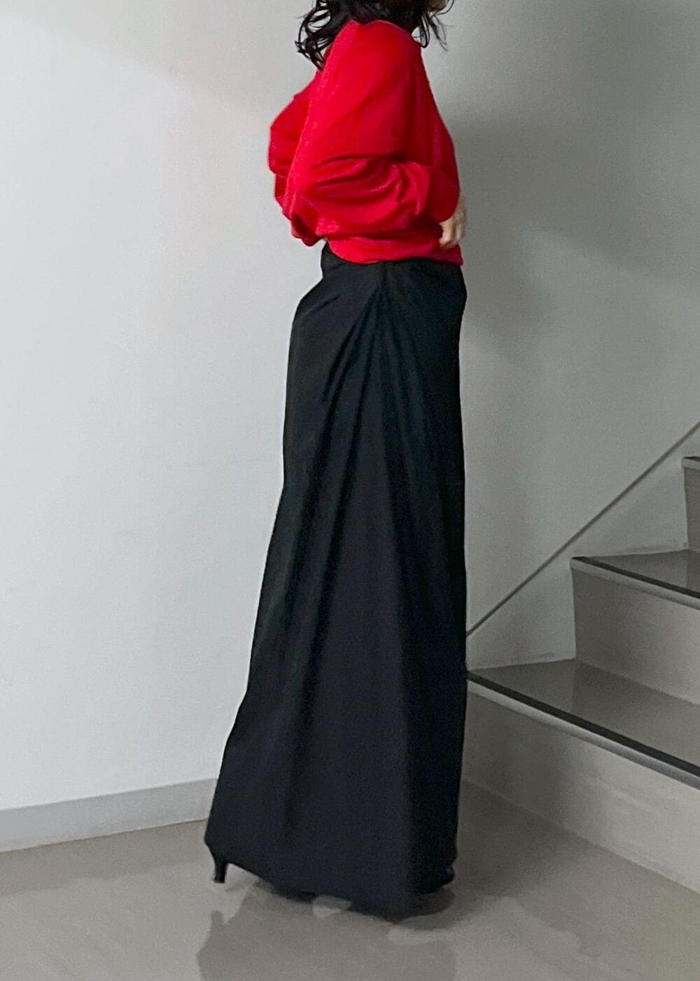 ブラック系のスカート、レッド系のニット/セーター、グレー系のスカートを着用したレディースの秋コーディネートの7枚目の写真