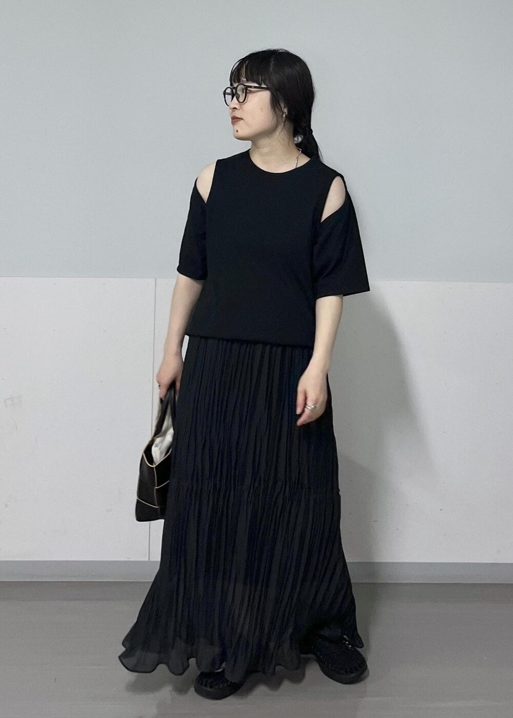 ブラック系のトートバッグ、ブラック系のTシャツ/カットソー、ブラック系のサンダルを着用したレディースの春コーディネートの3枚目の写真