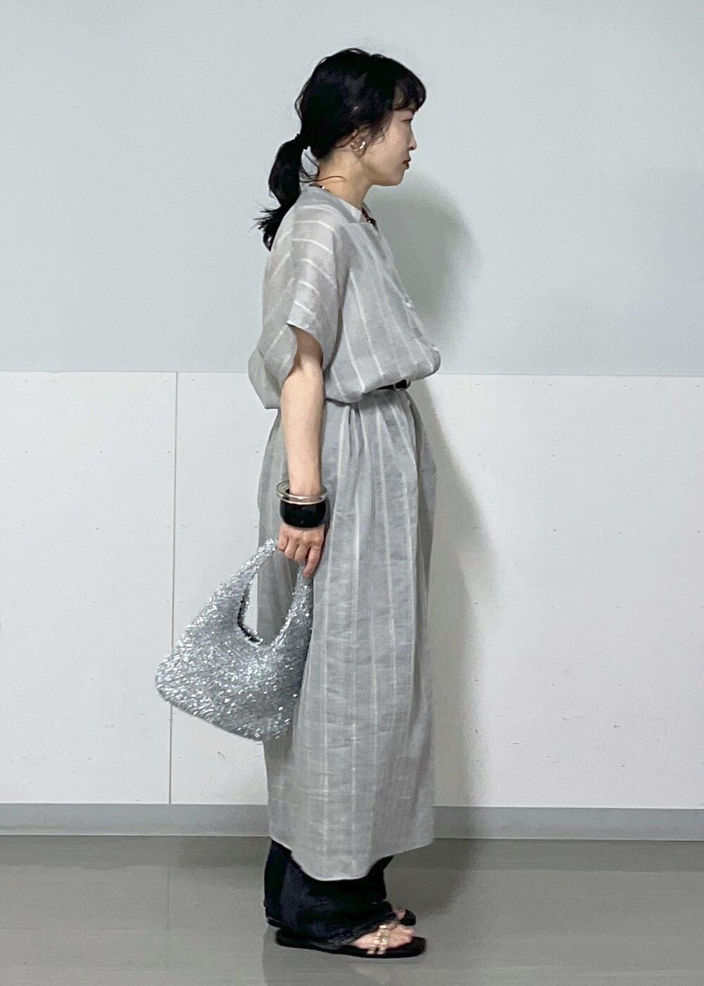 ブルー系のワンピース、ホワイト系のタンクトップ、シルバー系のハンドバッグを着用したレディースの夏コーディネートの2枚目の写真